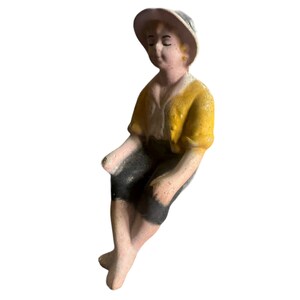 Vintage bisque figurine of a sitting boy