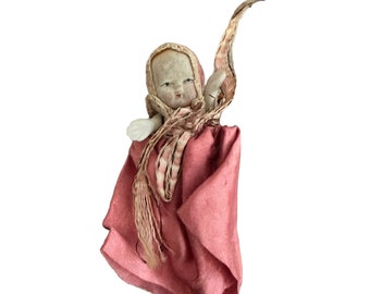 Small antique bisque doll in pink outfit