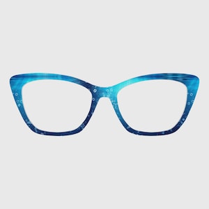 Puede incluir: Gafas de estilo ojo de gato con un patrón azul y turquesa con temática de agua. Las monturas presentan un diseño degradado con burbujas, creando un aspecto único. Las lentes son transparentes y el diseño general es moderno y llamativo.