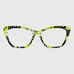May include: Cat-eye style eyeglasses with a colorful patchwork design. The frames feature a mix of patterns, including white daisies, black polka dots, and green and yellow geometric shapes. The lenses are clear.