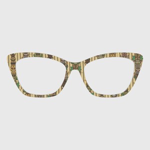 Puede incluir: Gafas de estilo ojo de gato con un patrón de bambú y máscaras tiki. Las monturas presentan un fondo de color beige claro con tallos de bambú verticales y varios diseños de máscaras tiki coloridas en tonos marrón, verde y beige.