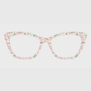 May include: Cat-eye glasses with a cream-colored frame featuring a repeating pattern of pink cowboy boots, pink cowboy hats, green cacti, and small pink hearts. The lenses are clear and the frame has a distinct pointed outer edge design.