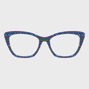 Puede incluir: Gafas azules de ojo de gato con un estampado festivo. Las monturas presentan un diseño repetido de barcos, árboles y otros elementos temáticos navideños en rojo, verde y blanco. El texto "Bye Buddy, Hope You Find Your Dad" está impreso en la parte inferior.