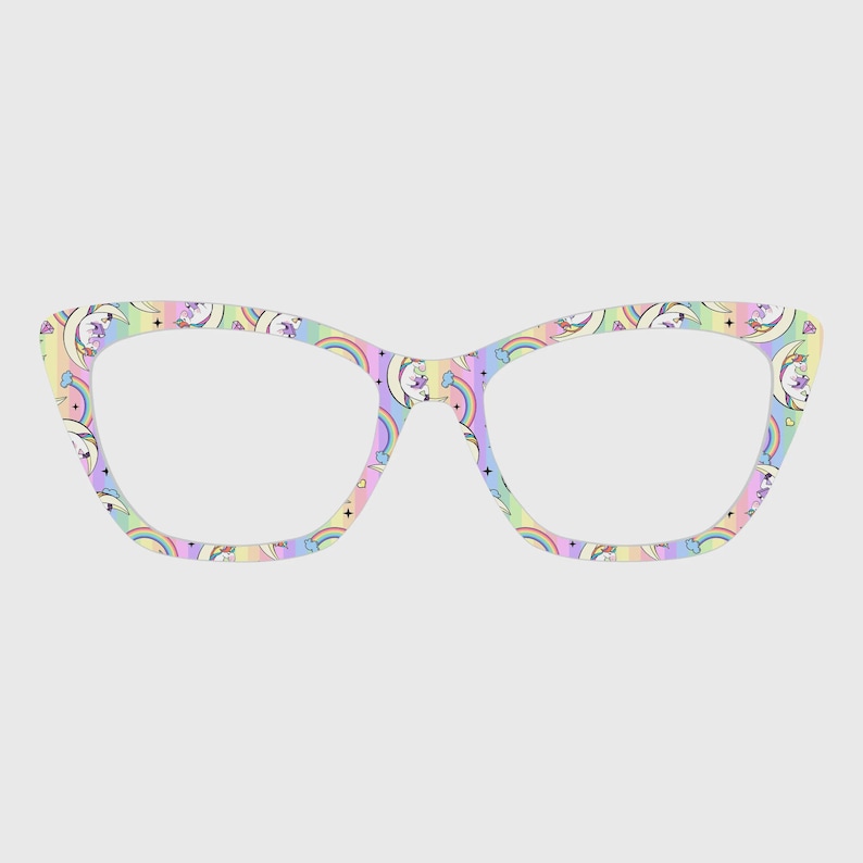 May include: Cat-eye style eyeglasses with a pastel rainbow and unicorn pattern. The frames feature a repeating design of rainbows, crescent moons, stars, and unicorns in shades of pink, yellow, blue, and purple. The glasses have a light-colored background.
