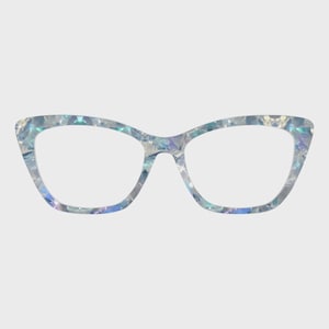 May include: Cat-eye style eyeglasses with a shimmering, iridescent frame. The frame features a mosaic-like pattern with shades of blue, silver, and hints of purple. The lenses are clear, and the overall design is modern and stylish.