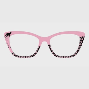 May include: Pink cat-eye glasses with black paw prints along the bottom and on the outer corners. A black cat silhouette is on the upper left corner. The glasses have a playful and whimsical design.