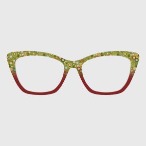 Puede incluir: Gafas de estilo ojo de gato con un diseño de montura en degradado. La parte superior de los aros muestra un patrón de pequeños círculos multicolores en tonos verdes, amarillos y marrones, que transicionan a un color rojo oscuro sólido abajo.