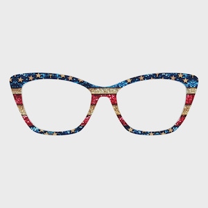 May include: Cat-eye style eyeglasses with a patriotic design. The frames feature a glittery pattern of blue with gold stars, red and gold stripes, and a clear lens.