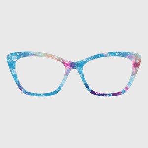 Puede incluir: Gafas de estilo ojo de gato con un colorido patrón de burbujas en tonos de azul, rosa y morado. Las monturas tienen un acabado brillante y una forma clásica y femenina. Las lentes son transparentes.
