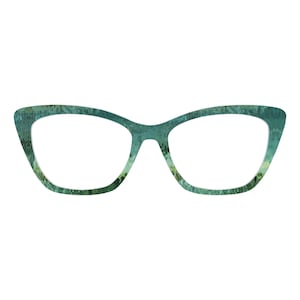 Może przedstawiać: Okulary w stylu kociego oka z teksturowanym wzorem w kolorze turkusowym i zielonym. Oprawki mają unikalny design, z lekko skierowaną ku górze krzywizną na zewnętrznych krawędziach. Soczewki są przezroczyste.
