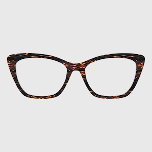 May include: Cat-eye spectacles with a dark brown and orange patterned frame. The glasses have a classic shape with a pointed outer edge. The frame features a repeating geometric design in shades of brown and orange.