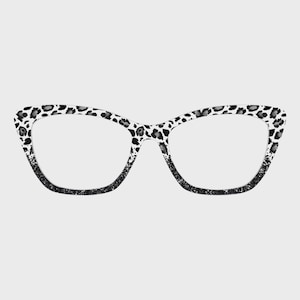 May include: Cat-eye spectacles with a black and white leopard print pattern on the frames. The bottom of the frames fade to a black glitter effect. The glasses have clear lenses.
