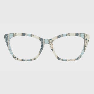May include: Cat-eye glasses featuring a cream-colored frame with a decorative pattern of blue and white vertical stripes, intricate floral motifs, and lace-like detailing. The design covers the entire front of the frame, including the bridge.