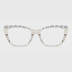 Peut inclure: Lunettes de style œil de chat avec une monture crème. La monture présente un motif floral et géométrique en bleu, marron et gris. Les verres sont clairs et le design est d'inspiration vintage.