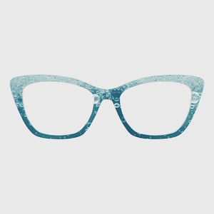 Puede incluir: Gafas de ojo de gato con una montura degradada que pasa de un azul verdoso claro y brillante en la parte superior a un azul profundo sólido en la parte inferior. La montura está decorada con un patrón de burbujas translúcidas de varios tamaños.