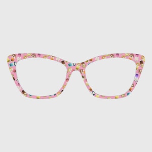 Puede incluir: Gafas rosas de ojo de gato con un patrón repetido de ilustraciones coloridas de alimentos. Las monturas tienen un fondo rosa claro y lentes transparentes. El diseño es juguetón y caprichoso.
