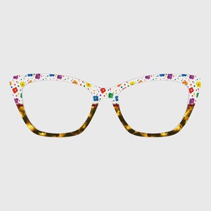 May include: Cat-eye style eyeglasses with a white frame decorated with colorful flowers. The lower portion of the frame has a tortoise shell pattern. The lenses are clear.