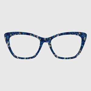 Puede incluir: Gafas de estilo ojo de gato con una montura de color azul profundo con un patrón jaspeado y motas de color dorado repartidas por todo el material. El diseño presenta un borde exterior puntiagudo y un acabado liso y brillante frontal.