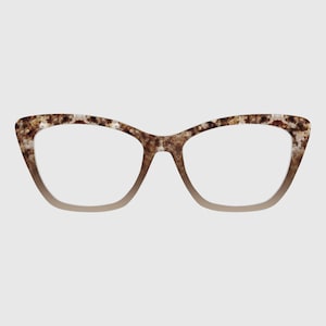 May include: Cat-eye eyeglasses with a speckled brown and tan pattern on the frames. The frames have a gradient effect, transitioning from a light tan to the speckled pattern. The lenses are clear.