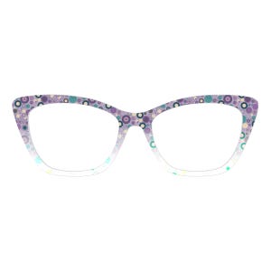 Puede incluir: Gafas de estilo ojo de gato con montura degradada de blanco a morado claro. Las monturas están decoradas con un patrón de círculos coloridos en tonos morado, verde azulado y amarillo. Las gafas tienen lentes transparentes.