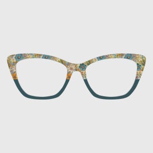 Puede incluir: Gafas de vista con forma de ojo de gato y estampado floral. Las monturas presentan flores azules, amarillas y blancas. La parte inferior de las monturas es de color turquesa liso.