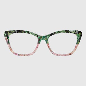 May include: Cat-eye spectacles with a distinctive patterned design. The frames display a collage of images in pink, green, and black. The lenses are clear, and the overall aesthetic is modern and stylish.