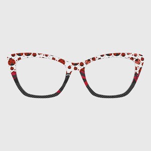 Puede incluir: Gafas de ojo de gato con montura blanca estampada con mariquitas rojas y pequeñas estrellas. Las patillas son negras con lunares blancos. Las patillas interiores tienen un diseño estampado en rojo y negro.