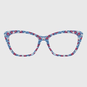 May include: Cat-eye style eyeglasses with a blue floral pattern. The frames feature a repeating pattern of small red, white, and blue flowers. The glasses have a classic, feminine shape and are set against a plain background.