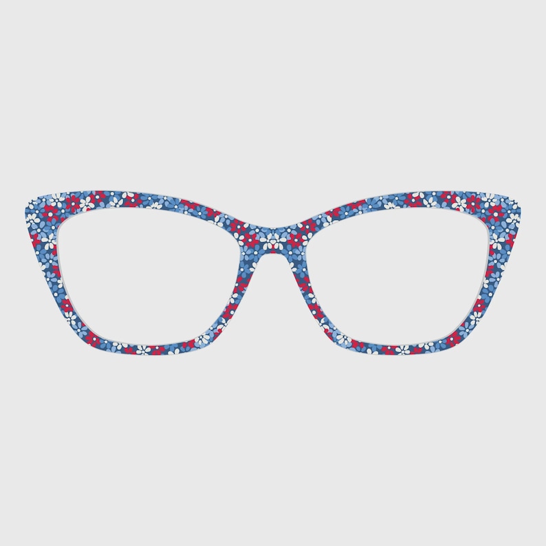 May include: Cat-eye style eyeglasses with a blue floral pattern. The frames feature a repeating pattern of small red, white, and blue flowers. The glasses have a classic, feminine shape and are set against a plain background.