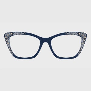 Puede incluir: Gafas de ojo de gato con montura de textura vaquera azul oscuro. Las esquinas exteriores presentan patrones de bordado floral blanco acentuados con pequeñas perlas artificiales de color crema incrustadas en los bordes.