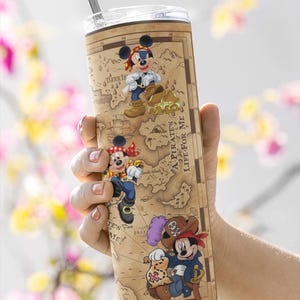 K&ouml;nnte beinhalten: Ein hoher Edelstahlbecher mit Piraten-Design mit Mickey Mouse-Figuren. Der Becher hat einen Kartenhintergrund und den Text "A Pirate's Life For Me". Er enth&auml;lt einen silbernen Strohhalm.
