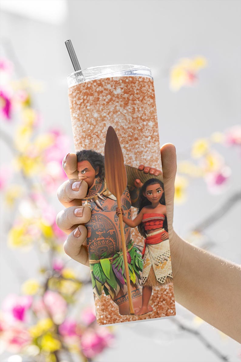May include: A stainless steel tumbler with a glittery orange background and a design featuring characters from the animated film Moana. The tumbler includes a straw and a clear lid. The characters include Maui and Moana.