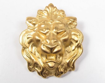 May include: A gold lion's head sculpture with intricate details. The lion's mane is sculpted with flowing curls and the face is fierce with a snarling expression.