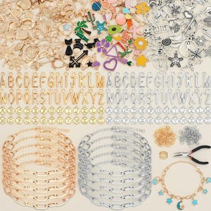 May include: A selection of jewellery-making components, including gold and silver charms, alphabet pendants, chain bracelets, and tools. Charms feature various shapes and colours, with letters A-Z in gold and silver.