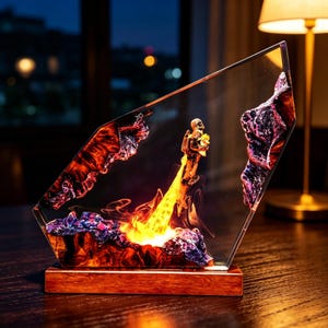 May include: A decorative resin sculpture featuring an astronaut with a bouquet of flowers, ascending on a jet of fire. The sculpture is set within a clear, angled frame with fiery red and purple accents, mounted on a wooden base.