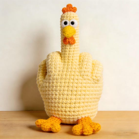 A hand-crocheted chicken defiantly flipping the bird — absurd, specific, and the kind of thing you keep on your desk just to explain it to people.