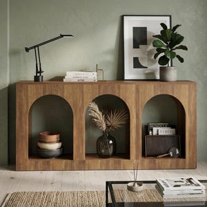 May include: A white ceramic mug with a black handle and the text "But First, Coffee" in a black, handwritten-style font. The mug is on a white surface.