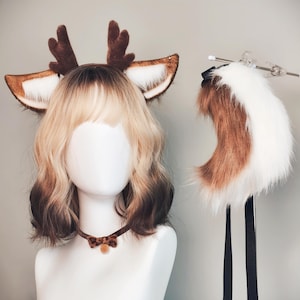 Op de afbeelding: Een kostuumset met hertenthema. Het bevat een hoofdband met bruine geweien en imitatiebont oren, een bijpassende staart en een luipaardprint kraag met een kleine oranje pompon. Ideaal voor cosplay of thema-evenementen.