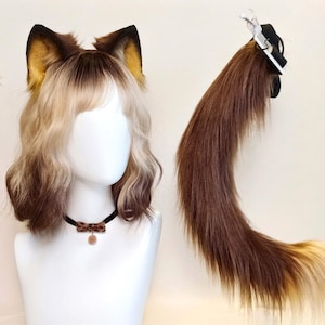 Può includere: Un set composto da una parrucca sfumata marrone e bionda con orecchie da animale, un girocollo nero con un piccolo fiocco leopardato e un ciondolo, e una lunga coda in pelliccia sintetica sfumata marrone e bionda con una clip nera.