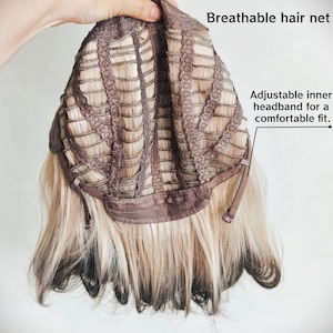 K&ouml;nnte beinhalten: Das Innere einer Per&uuml;cke mit atmungsaktivem Haarnetz und verstellbarem Innenband f&uuml;r einen bequemen Sitz. Die Per&uuml;cke hat blondes Haar mit dunklen Ans&auml;tzen und dunklen Spitzen und zeigt die Konstruktion der Kappe mit braunen Stoffstreifen.