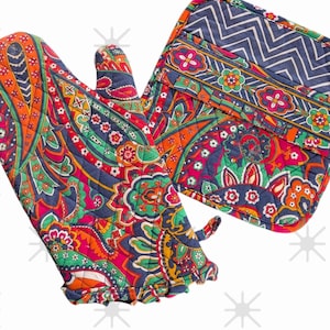 May include: A quilted oven mitt and pot holder set. The mitt features a vibrant paisley pattern in red, orange, green, and blue. The pot holder has a navy blue chevron pattern and a matching paisley border.