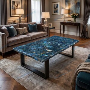 May include: A rectangular coffee table featuring a polished blue gemstone slab top with varied shades of azure and navy, supported by a sturdy black metal frame with two U-shaped legs, positioned centrally on a neutral-toned area rug.