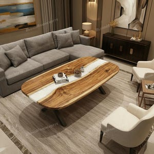 Könnte beinhalten: Ovaler Couchtisch aus Holz mit einem weißen Harzfluss-Design. Der Tisch hat eine natürliche Holzmaserung und steht auf schwarzen Metallbeinen. Die Wohnzimmereinrichtung umfasst ein graues Ecksofa, weiße Stühle und einen neutralen Teppich.