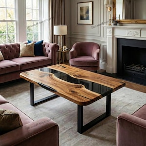 Puede incluir: Una mesa de centro rectangular de madera con un centro de resina epoxi negra. La mesa tiene un patrón de vetas de madera natural y se apoya sobre patas de metal negro. La mesa está en un salón con un sofá y sillas.