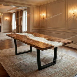 May include: A large, rectangular wooden table with a river of white resin running through the center. The table has a dark brown finish and black metal legs. The table is in a well-lit room with a rug.