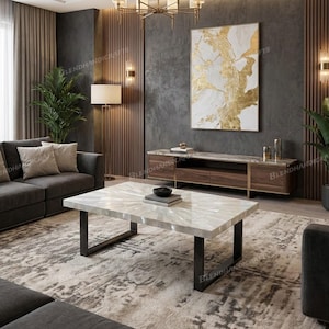 May include: A contemporary living room with a rectangular coffee table. The table has a light-coloured, patterned top and black metal legs. A dark grey sofa, a patterned rug, and a wooden cabinet with gold accents are also visible. An abstract painting hangs on the wall.