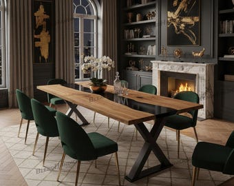 May include: A contemporary dining room with a large wooden dining table with a black central section and a black metal base. It is surrounded by green velvet chairs with gold legs. The room has dark walls, a fireplace, and decorative art.