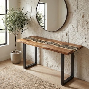 Puede incluir: Una consola de madera con incrustaciones de cantos rodados y patas de metal negro. La parte superior de la mesa es de color marrón cálido, con un canal central lleno de piedras lisas grises y marrones. Las patas son de color negro mate.