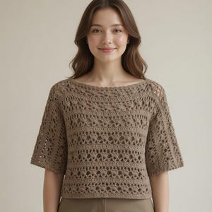 May include: A light brown crochet top with short sleeves. The top features an open, textured design with a round neckline. The crochet pattern creates a delicate, airy look. The top is a neutral color, suitable for various outfits.