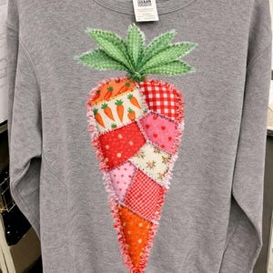 Könnte beinhalten: Eine weiße Keramik-Tasse mit schwarzem Henkel und dem Text "But First, Coffee" in fetter, schwarzer Schrift. Die Tasse steht vor einem verschwommenen Hintergrund, der eine gemütliche Umgebung suggeriert.